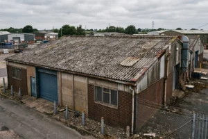 Weathered Big Six asbestos cement roof sheets on an industrial warehouse unit, industrial asbestos removal, asbestos cement roof replacement, industrial roof survey